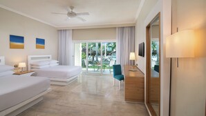 Une chambre d’hôtel avec deux lits, un bureau, une chaise, une télévision et un balcon donnant sur l’extérieur.