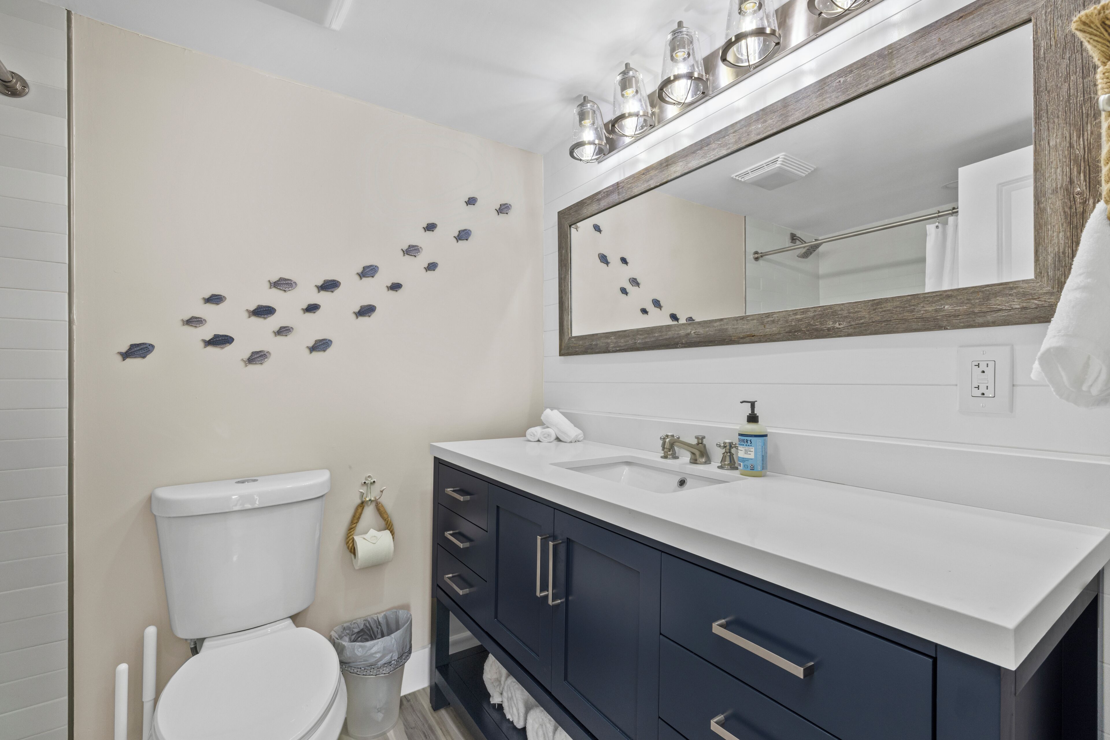 A modern bathroom with a white toilet, a sink, and a mirror.