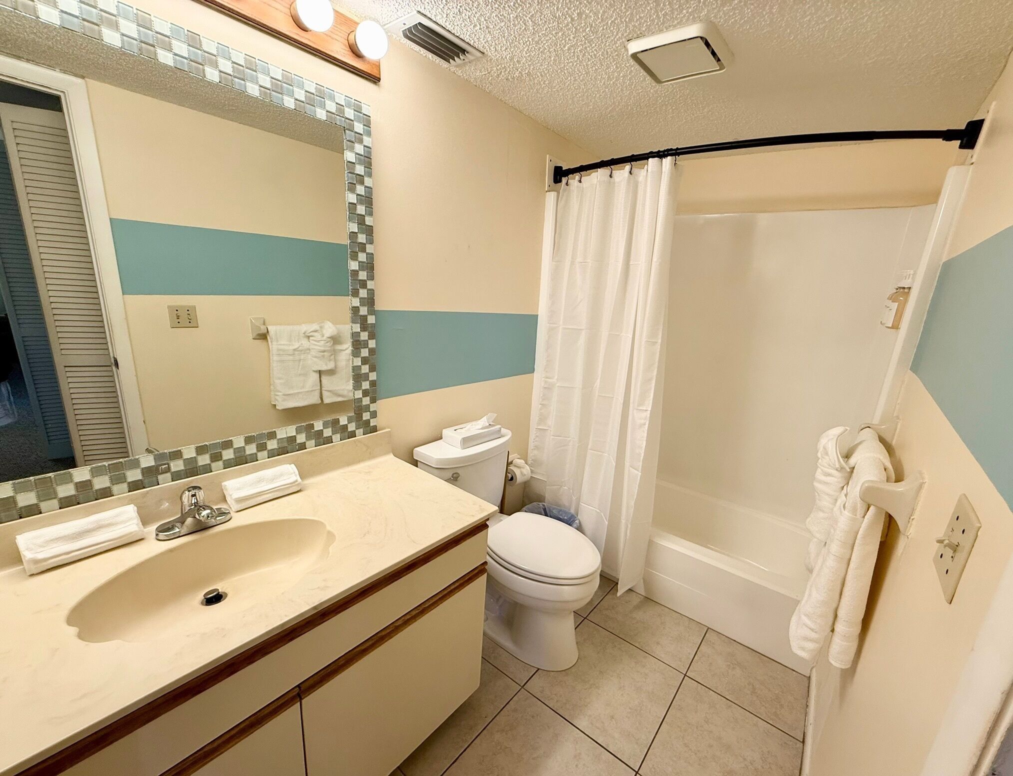 A bathroom with a sink, toilet, and shower area.
