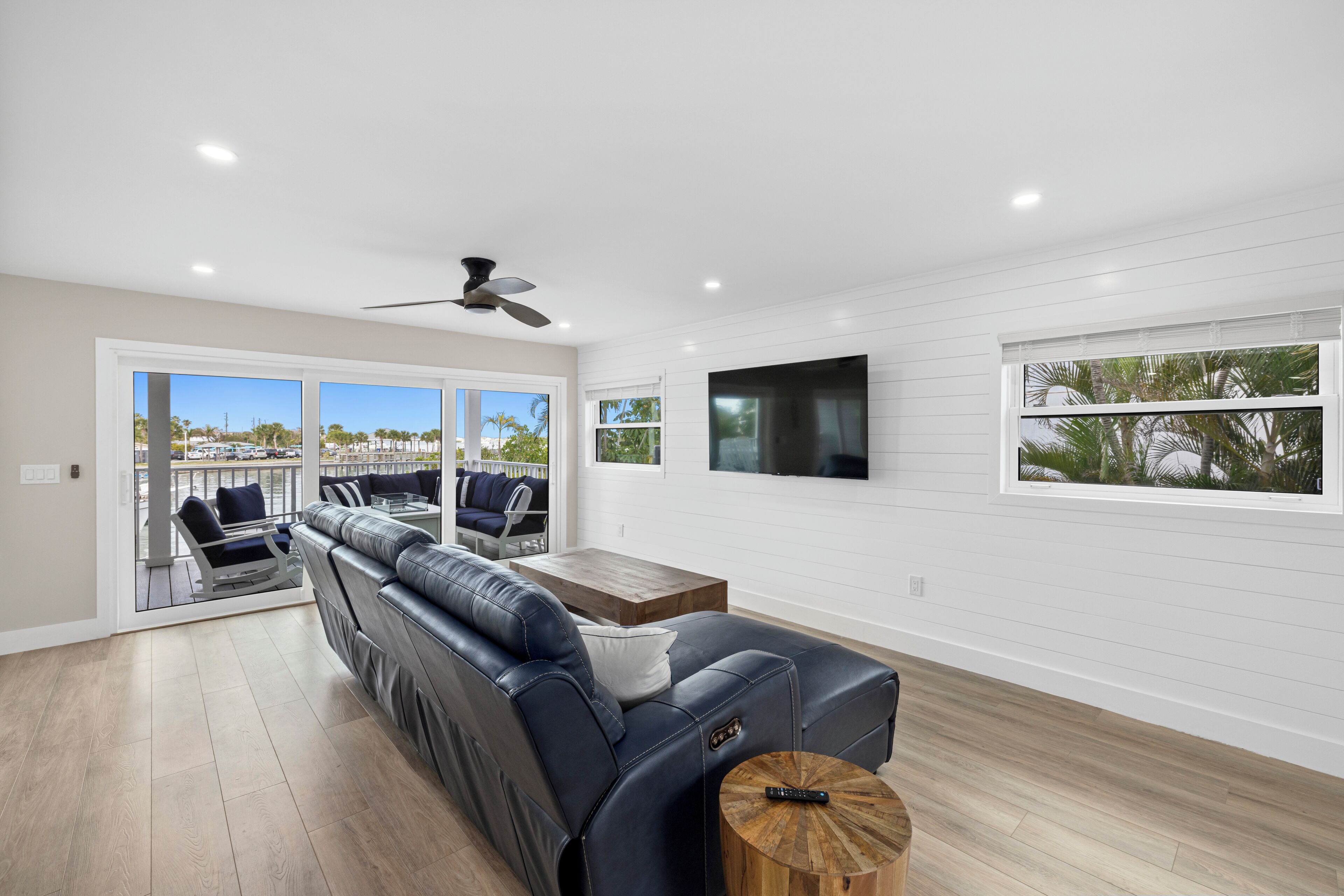 A modern living room with a leather sofa, a wooden coffee table, and a ceiling fan.