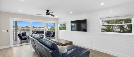 A modern living room with a leather sofa, a wooden coffee table, and a ceiling fan.