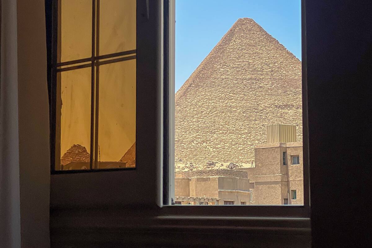 A window with a view of a pyramid and buildings.
