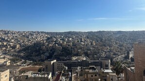 A cityscape with densely packed buildings and a clear blue sky.