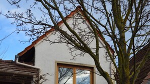 Un bâtiment à deux étages avec une porte en bois et une fenêtre.
