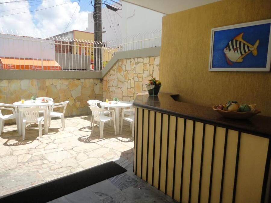A reception area with a stone wall, a wooden counter, and a framed fish painting.