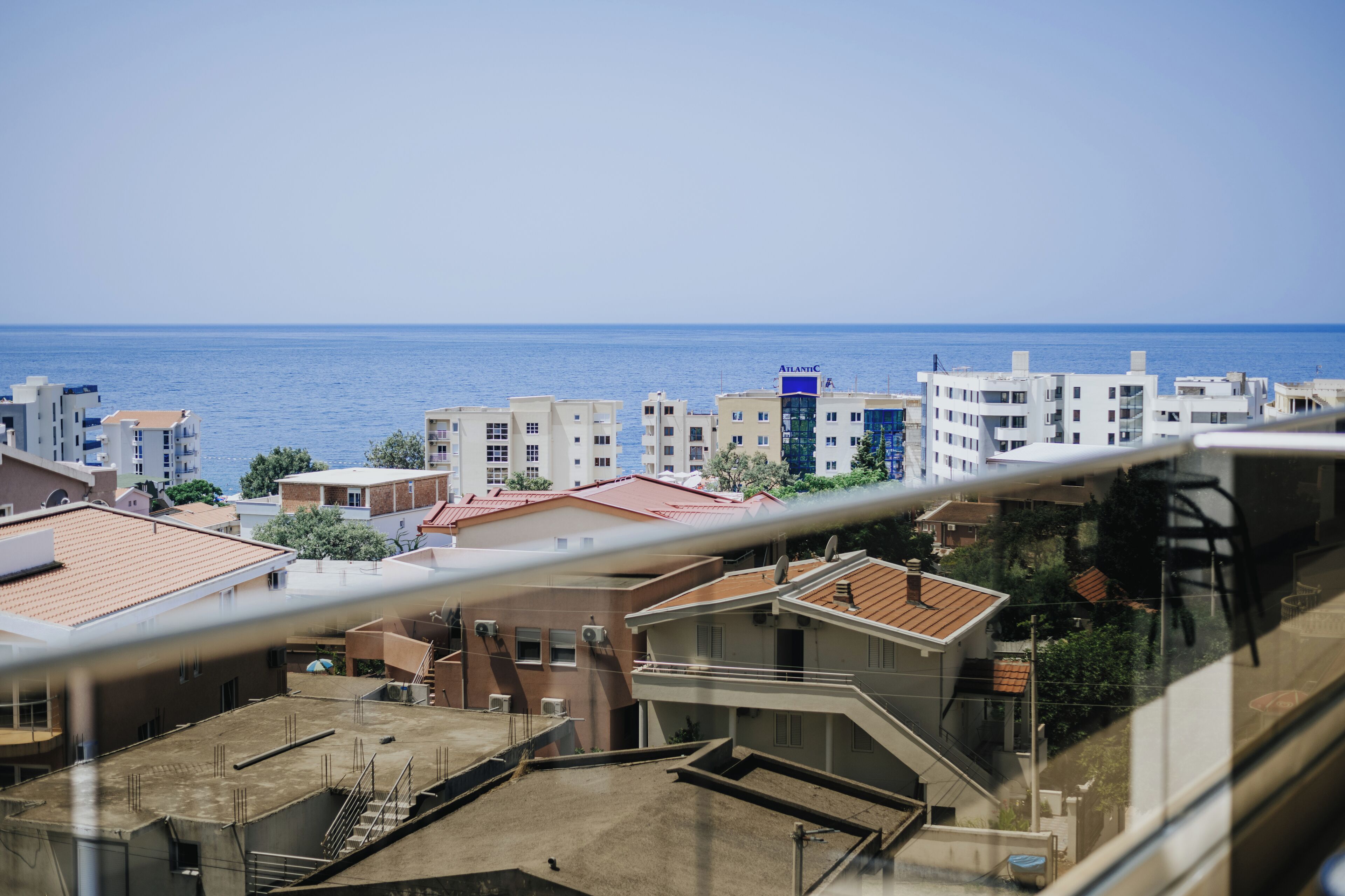 A coastal residential area with buildings and a view of the sea.