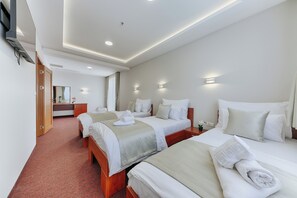 A hotel room with three beds, a wooden desk, and a mirror. - Casa Costa (Bar)