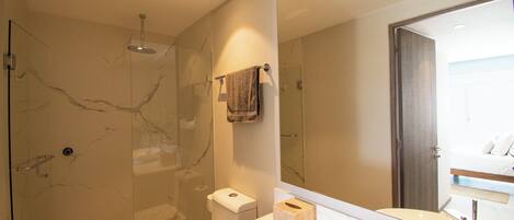 A modern bathroom with a glass-enclosed shower, a white sink, and a large mirror.