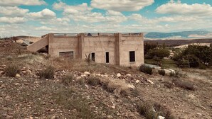 Un bâtiment rustique de plain-pied, doté d’un toit plat et d’un petit escalier menant à l’entrée.