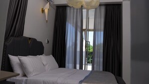 Une chambre d’hôtel moderne dotée d’un grand lit, d’un climatiseur fixé au mur et d’un luminaire au plafond original.