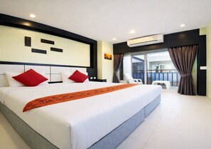 A modern hotel room with a large bed, a balcony with a view, and an air conditioning unit. - Star House Patong (Patong)