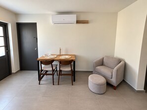 A dining area with a table, chairs, a sofa, and an ottoman.