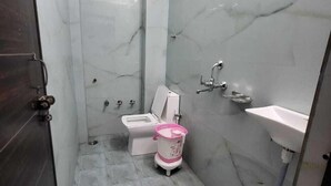 A small, modern bathroom with a toilet, bidet, and sink. - Shekhar Palace (Varanasi)