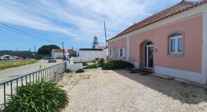 A residential building with a red-tiled roof, a gravel driveway, and a metal fence. - Alice's House, Private Pool, 7 km from Beach (Casal do Amaro, Alfeizerão)