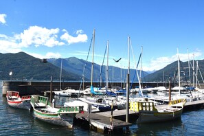 Un port de plaisance avec des bateaux amarrés à un quai, entouré de montagnes.