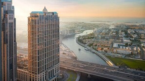 Ein Hochhaus-Hotel mit einer markanten Kuppel und Blick auf einen Fluss sowie die umliegende Skyline.