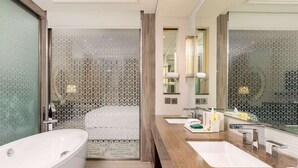 Ein modernes Badezimmer mit einer freistehenden Badewanne, einem Waschtisch mit Spiegel und einer Duschkabine.