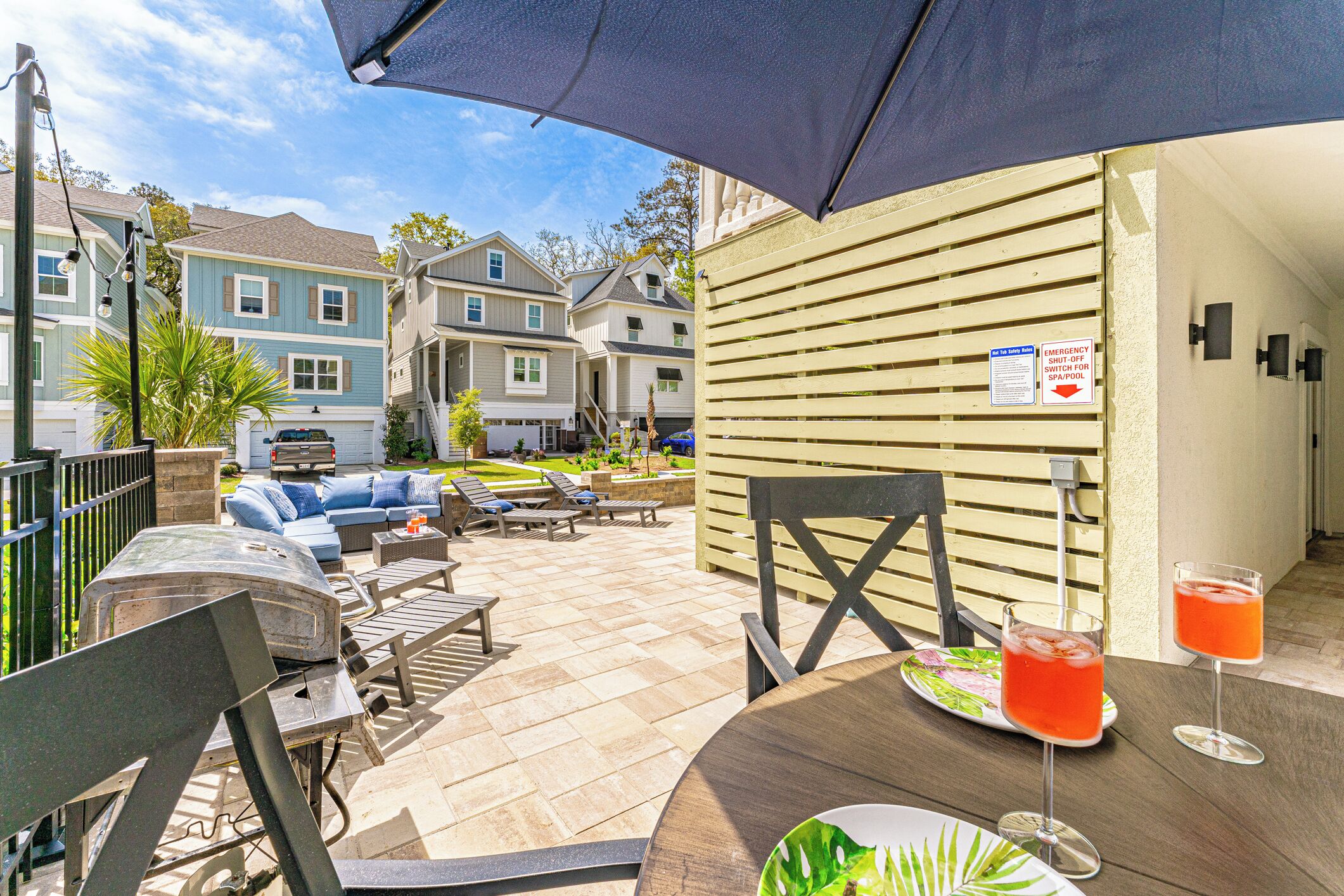 An outdoor patio with a grill, seating area, and drinks.