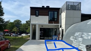 Un moderno edificio de dos plantas con acceso de vidrio y un letrero visible que dice 'Delano'.