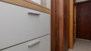 A narrow hallway with wooden flooring and white walls. - Apartments Roma - One Bedroom Apartment (Stanici)