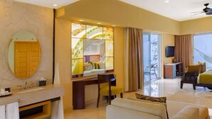 A modern hotel room with a large bed, a desk with a chair, a sofa, a balcony with a view, and a large window with curtains.