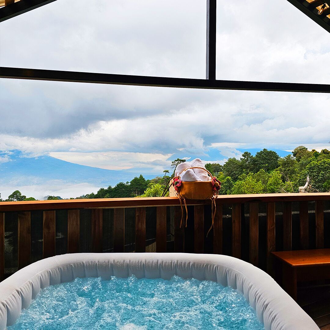 Ein Innenpool-Whirlpool mit Holzterrasse und Blick auf einen Berg.