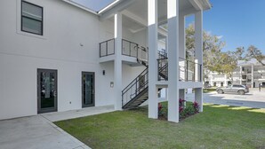 A modern building with a covered outdoor area, a staircase, and a parking lot. - Walkable Downtown LaBelle Apt w/ Private Balcony! (LaBelle)