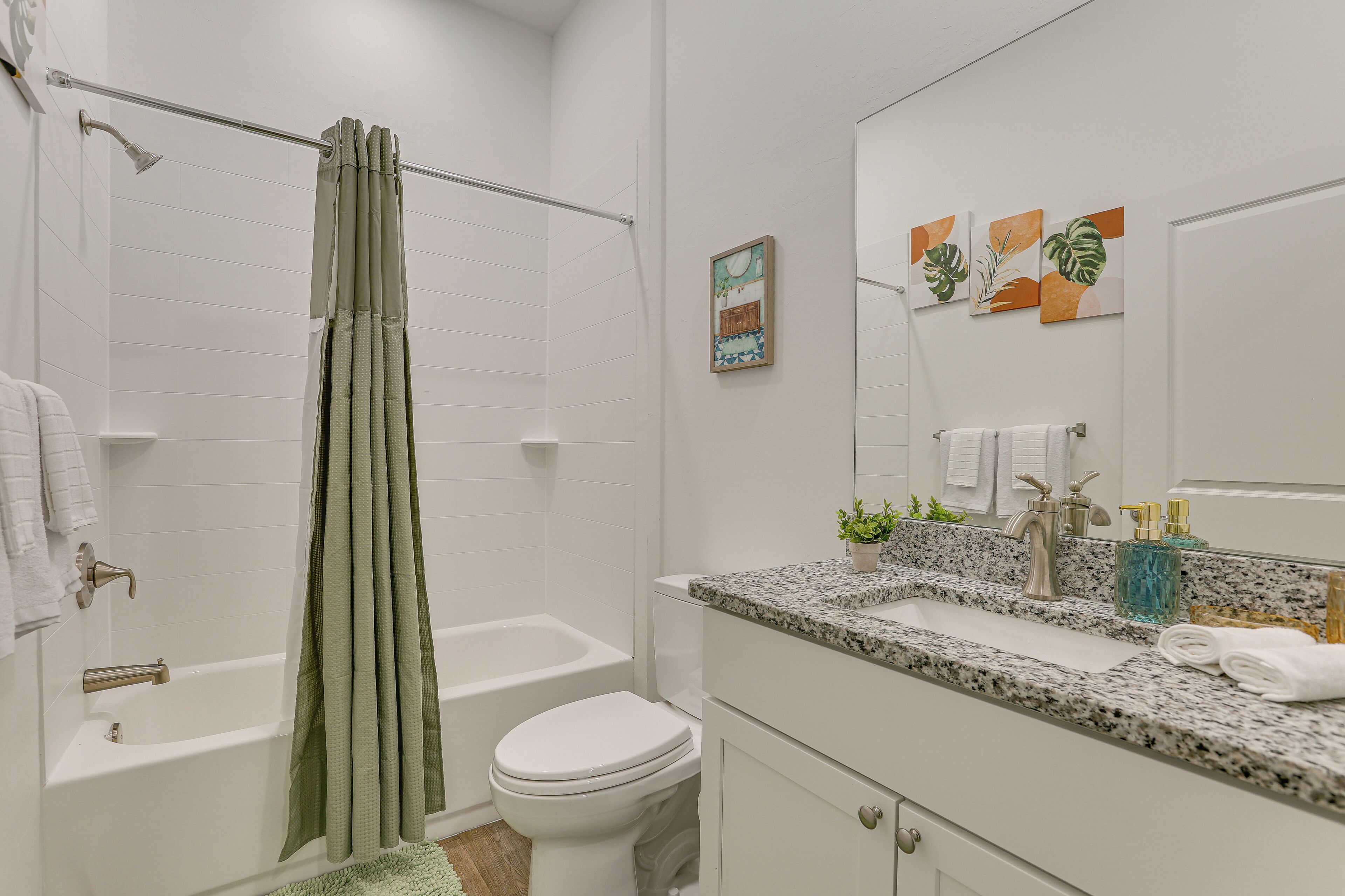 Une salle de bain moderne équipée d’une baignoire, de toilettes et d’un lavabo.