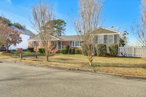 A two-story house with a front yard, a mailbox, and a white picket fence. - Waterfront Home w/ Deck & Yard in Hampton! (Hampton)