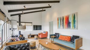 Uma sala de estar moderna com lareira, sofá, mesa de centro e uma pintura abstrata colorida.