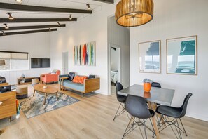 Un salon moderne avec un canapé, une table basse et un coin repas.