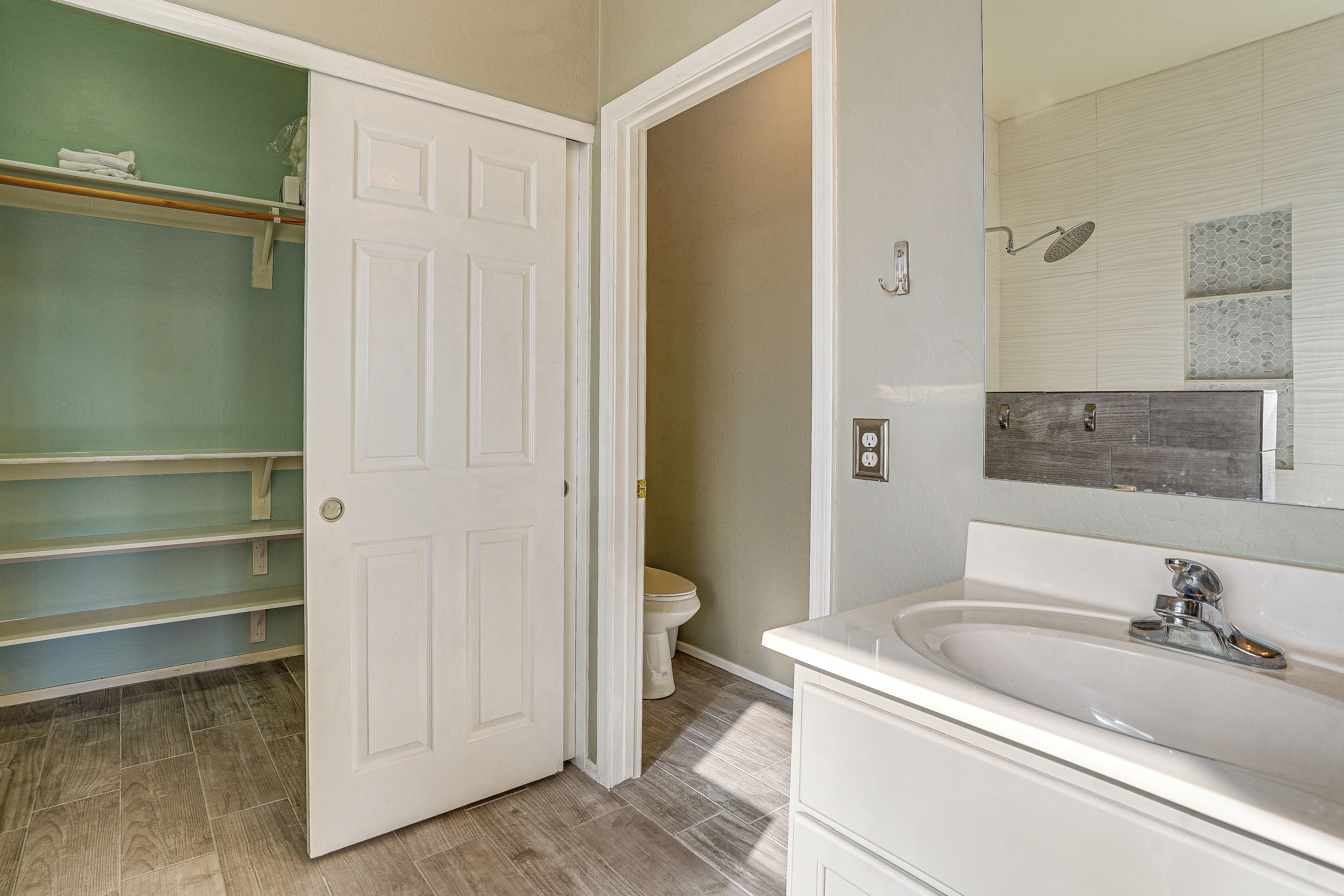 A bathroom with a white sink, a toilet, and a shower.
