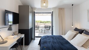 Une chambre d’hôtel moderne, équipée d’un lit, d’un bureau et offrant une vue sur l’extérieur.