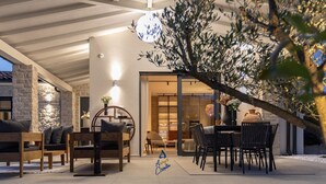 Un espace extérieur aménagé avec du mobilier en bois et un mur en pierre.