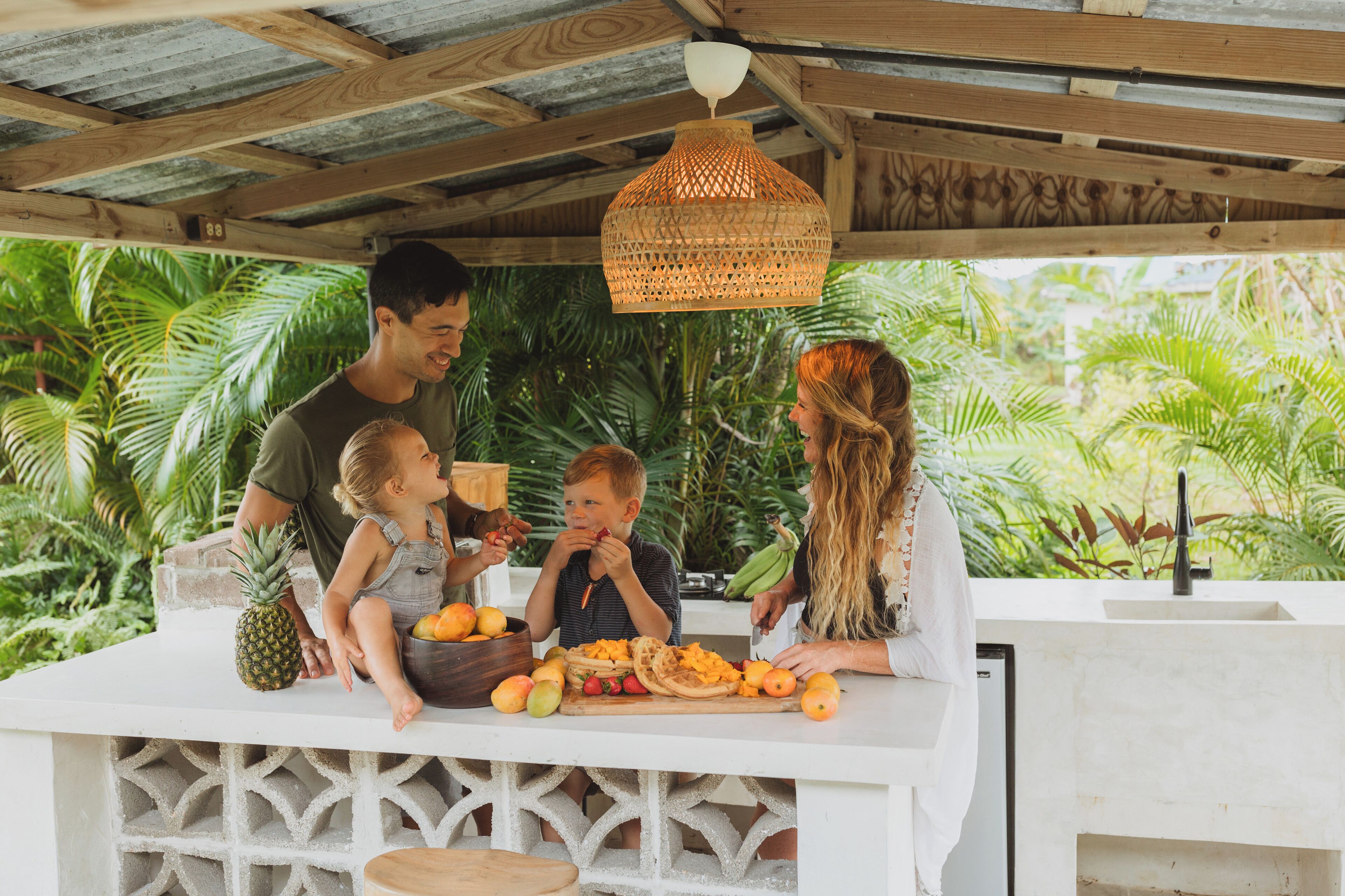 Une famille est assise à un bar, avec un décor tropical en arrière-plan.
