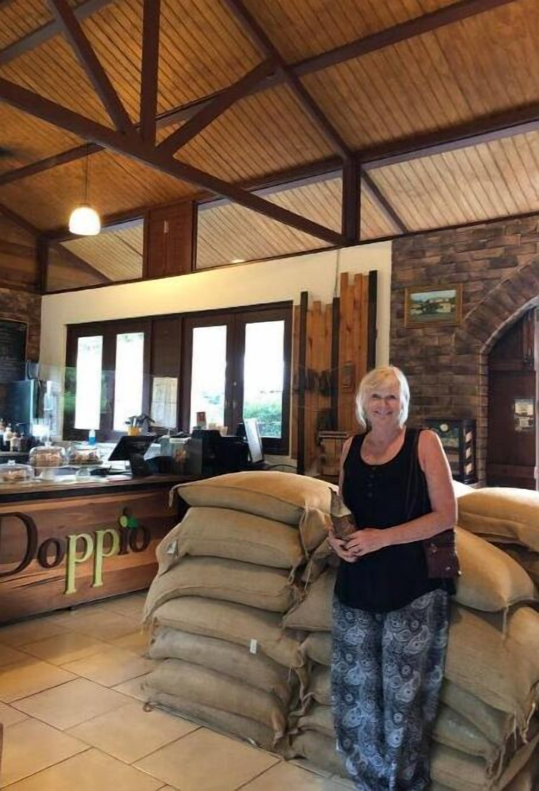 Un intérieur rustique avec une cheminée en pierre, des poutres en bois et un coin bar.
