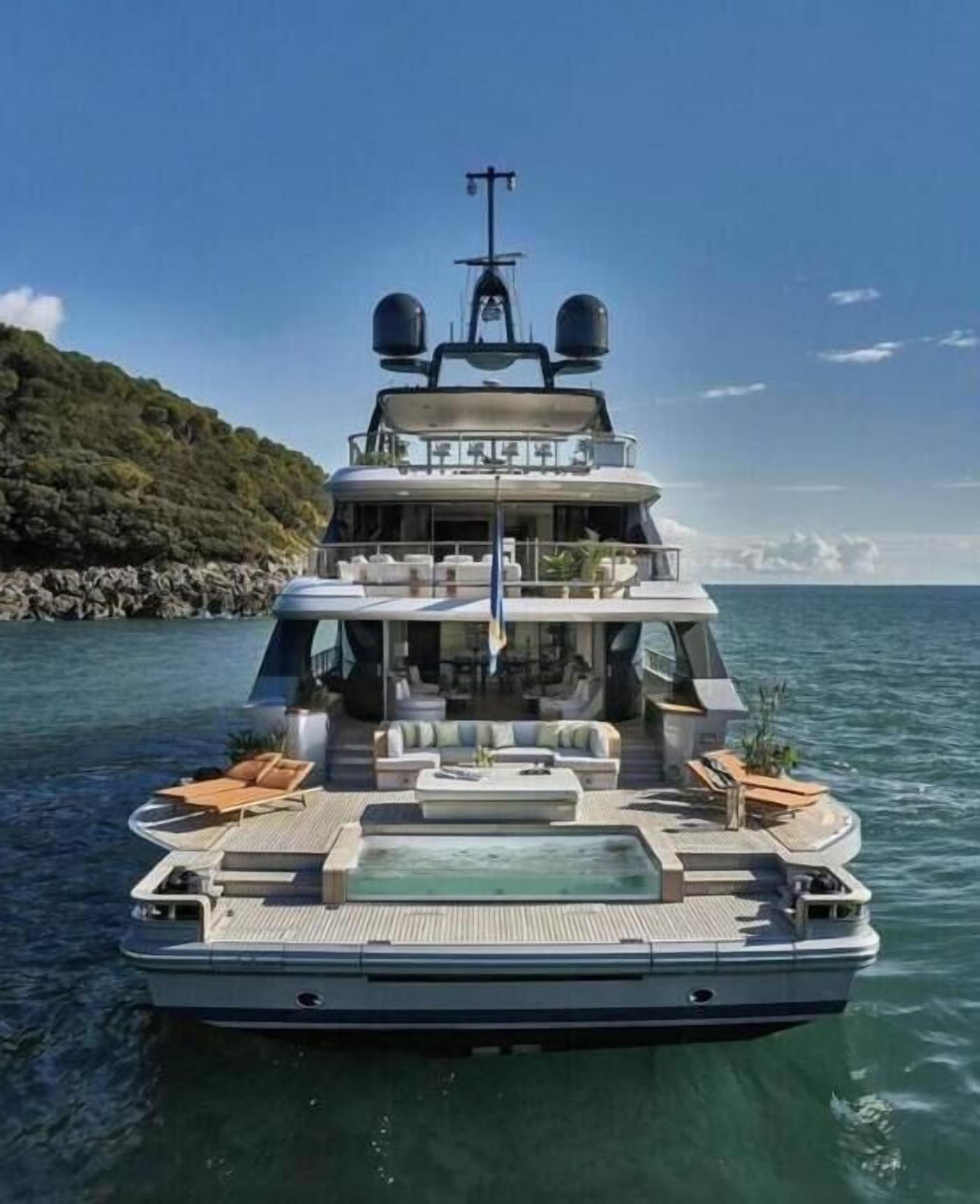 Un yacht à plusieurs ponts doté d’une piscine, d’un espace salon extérieur et d’un coin repas.