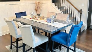 A dining area with a marble table, upholstered chairs, and a chandelier. - Spacious 5-bedroom house with AC and WiFi in charming Lawrenceville (Lawrenceville)