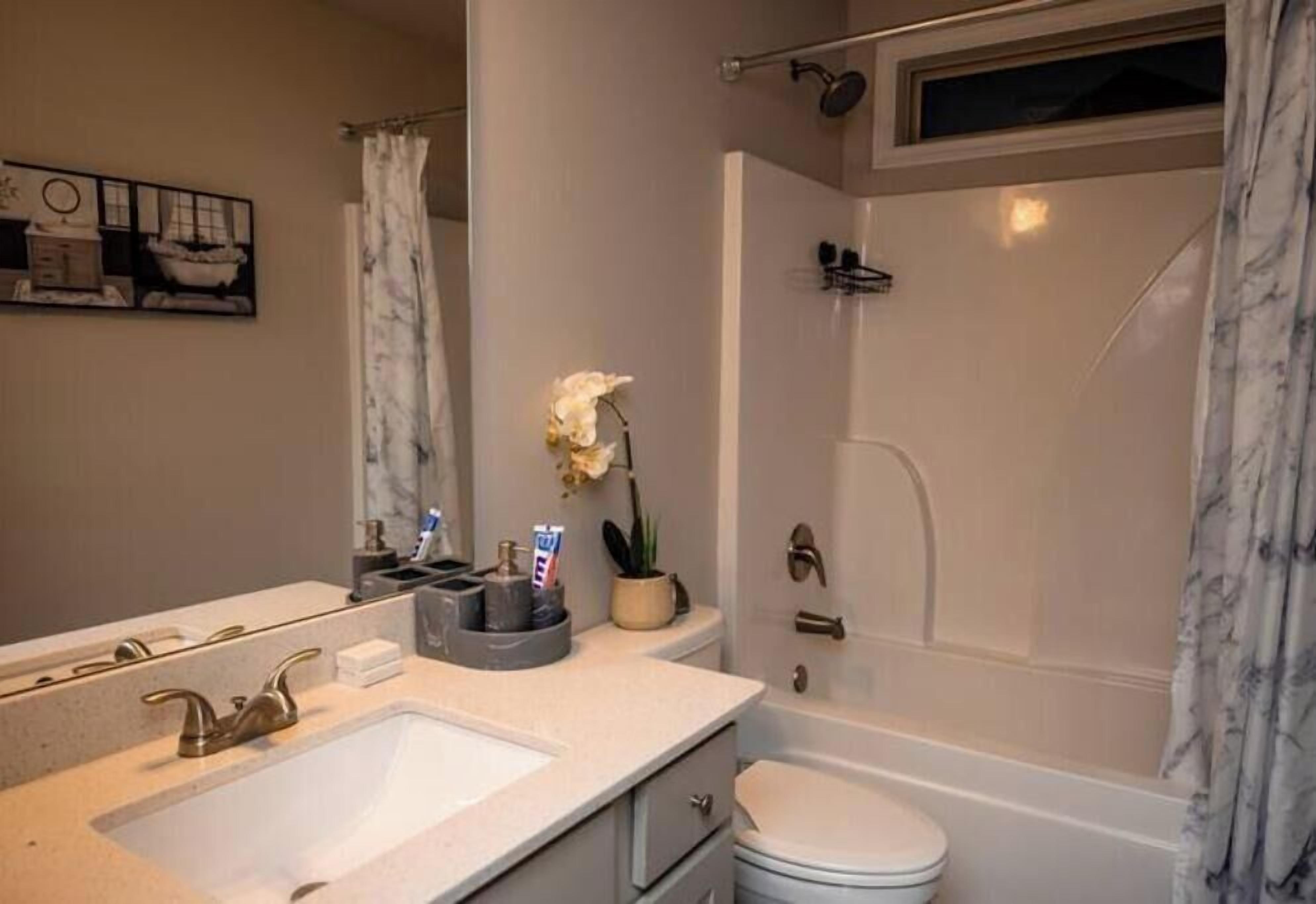 Un baño con lavamanos, inodoro y ducha.