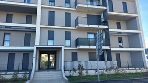 A multi-story residential building with balconies, a gated entrance, and a small garden area. - GOLD APARTMENT**** in the heart of Pula only 5 minutes from the sea (Pula)