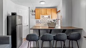 Una cocina moderna con una isla central, armarios de madera y un refrigerador negro.