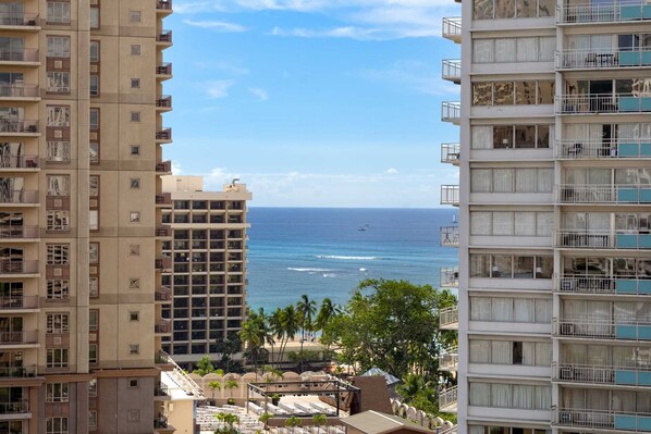 Un hotel de gran altura con múltiples balcones con vista a la playa y al océano.