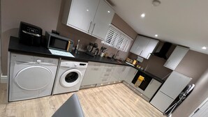 A modern kitchen with built-in appliances, including a washing machine and a microwave.