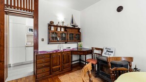 A kitchen with wooden cabinets, a stove, and a dining area with chairs and a table.