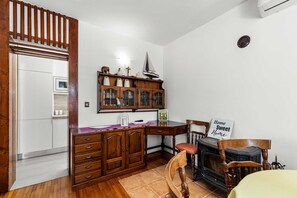 A kitchen with wooden cabinets, a stove, and a dining area with chairs and a table.