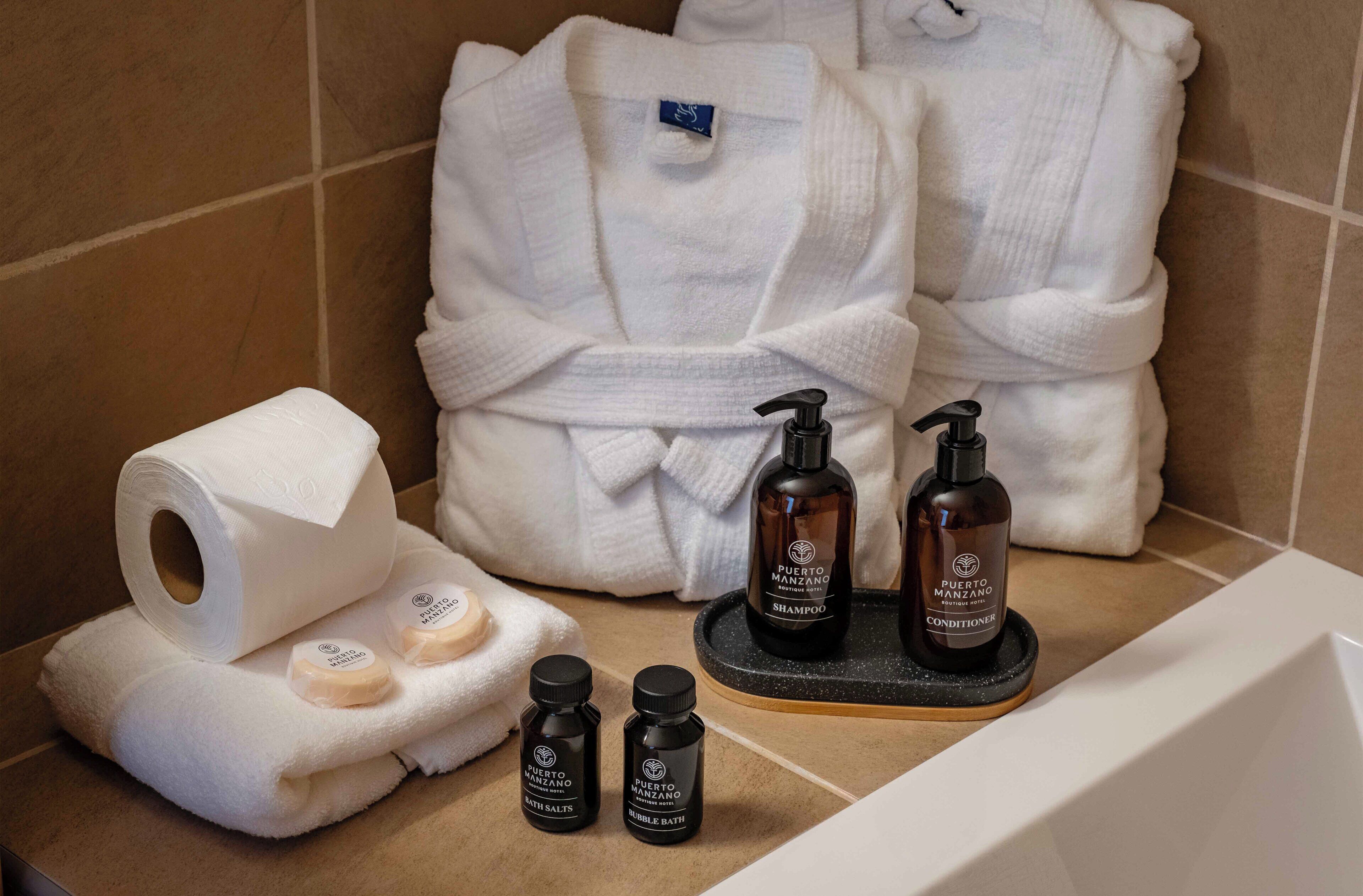 Ein Badezimmer mit Badewanne, Pflegeprodukten und einem weißen Bademantel.