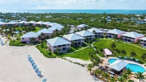 A resort with multiple buildings, a beach, and a pool area.