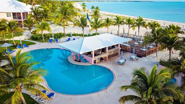 A resort with a large pool, beachside lounge, and a bar area.