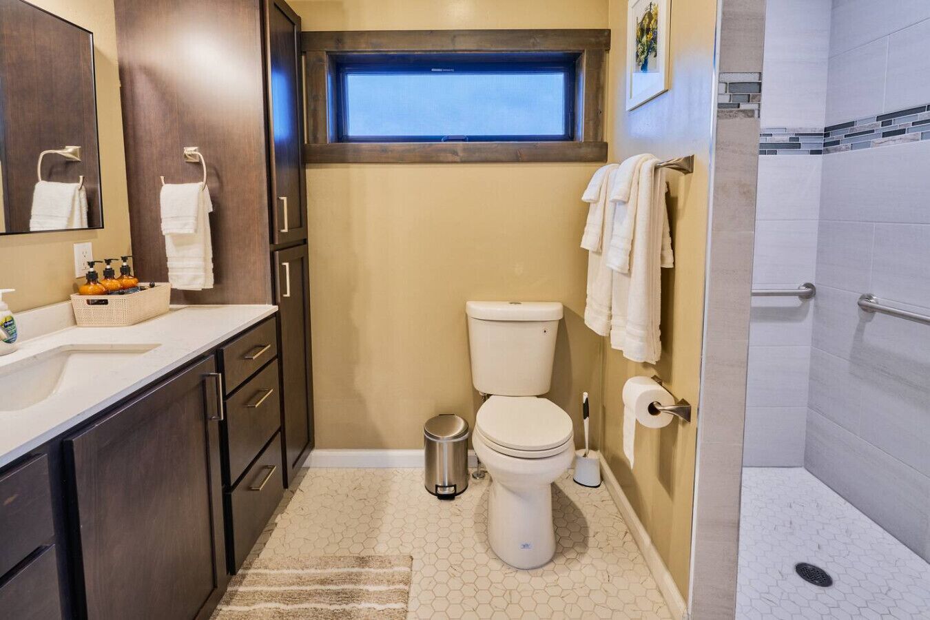 A compact bathroom with a toilet, sink, and shower.