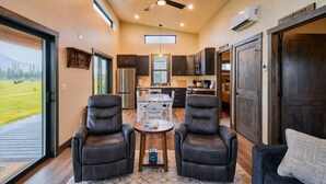 A spacious living area with leather chairs, a coffee table, and a sofa.